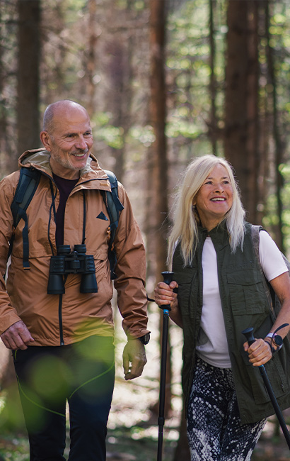 smiling couple hiking in the woods retirement income strategies bellevue wa