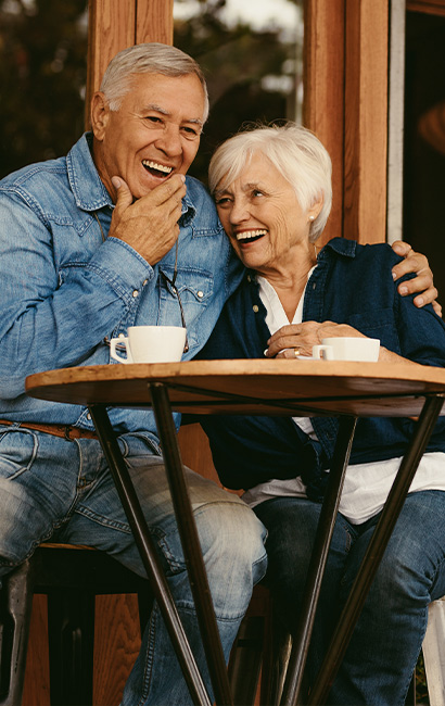 smiling senior couple sitting outside of cafe keys to a successful retirement bellevue wa